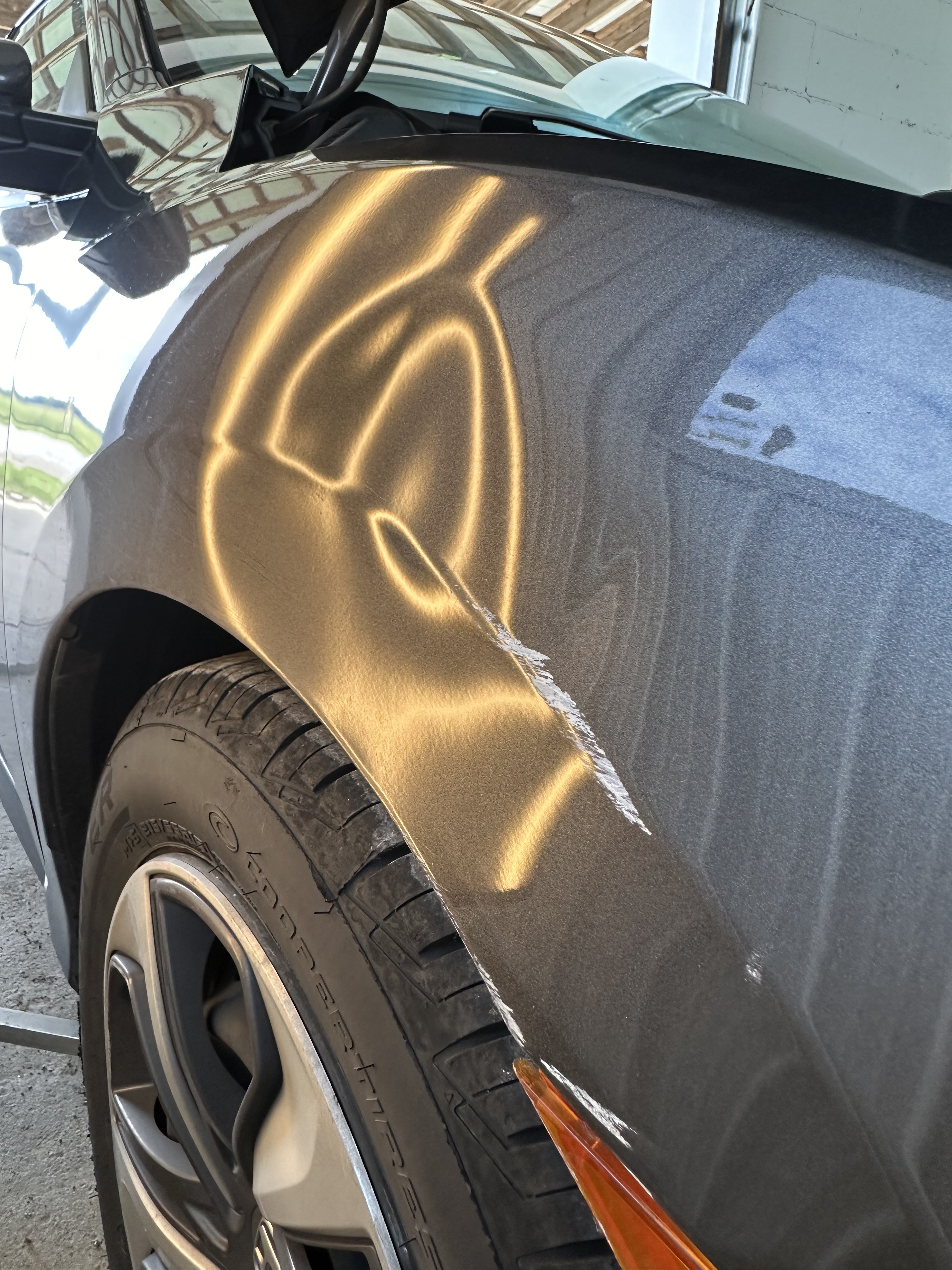 Car fender with severe dent and crease damage before PDR repair